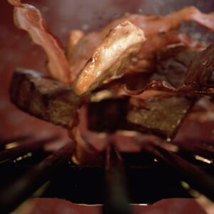 Meat And Bacon Falling On Grill